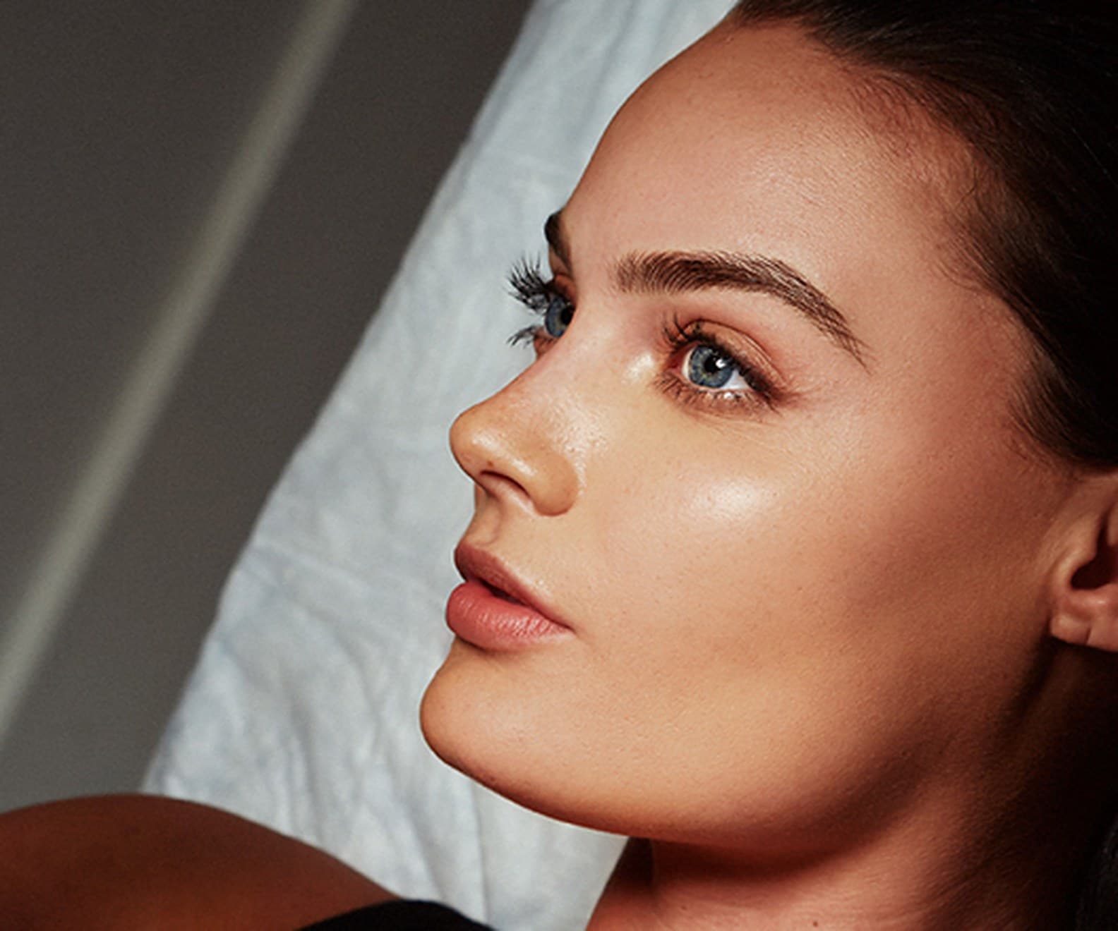 Microblading LA model lying back on a treatment bed in the studio